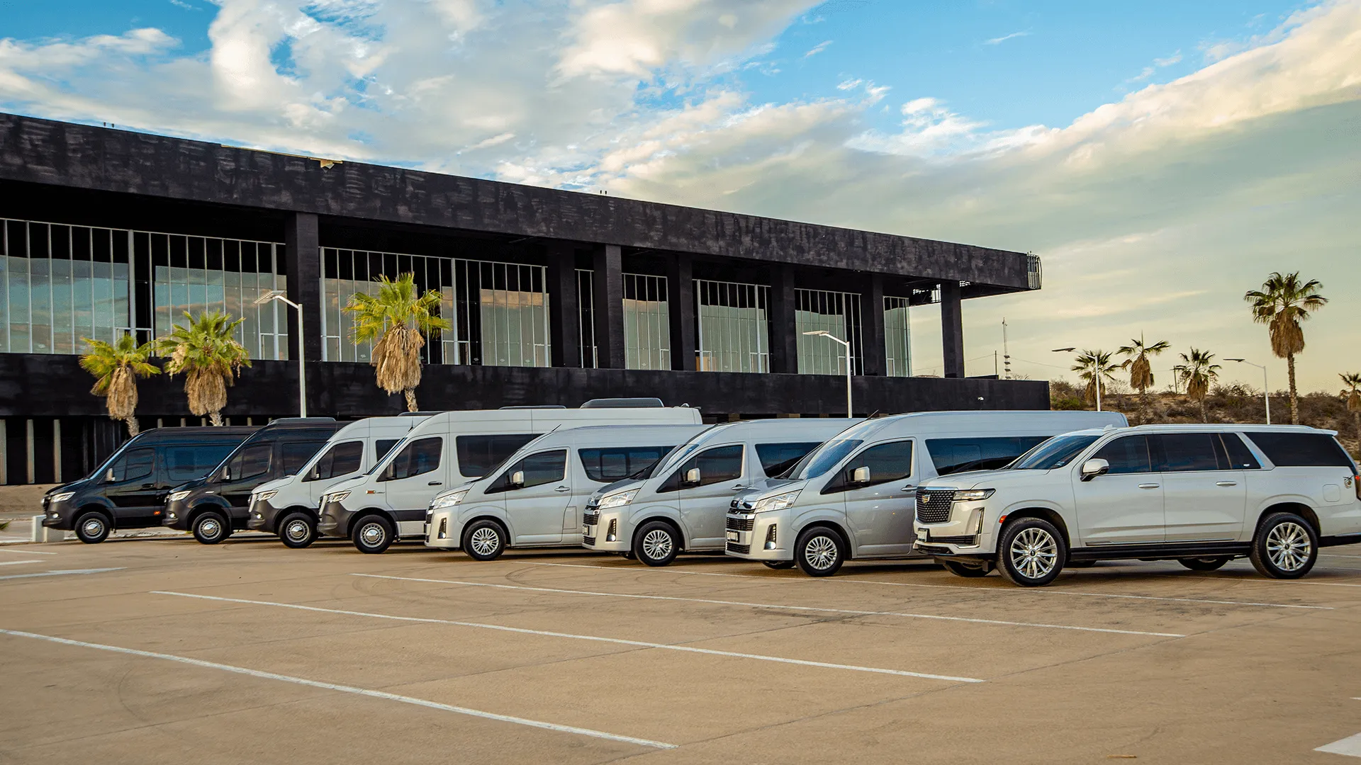 Cabo T&T vans parked outside the airport terminal